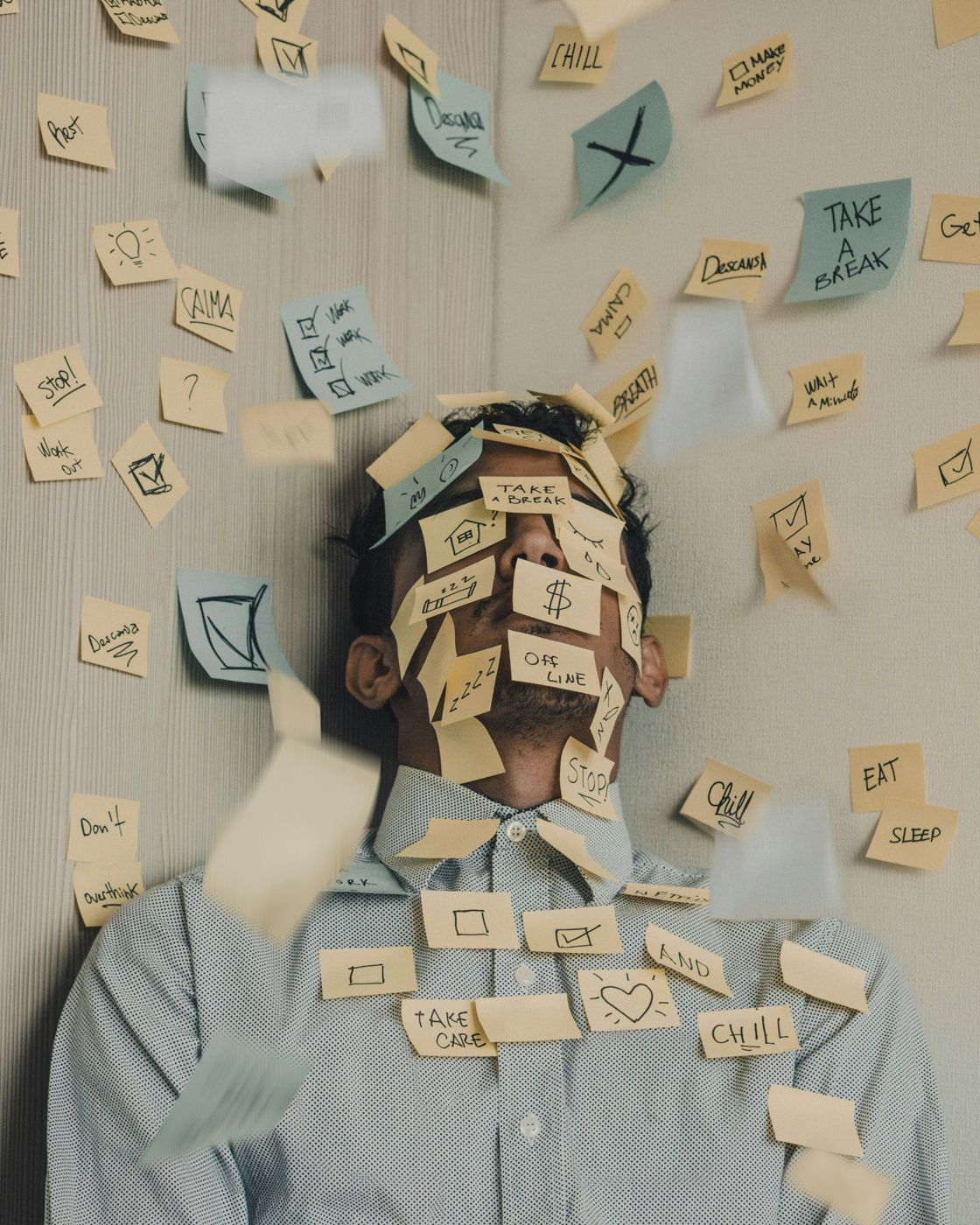A person overwhelmed by sticky notes about money, work and rest